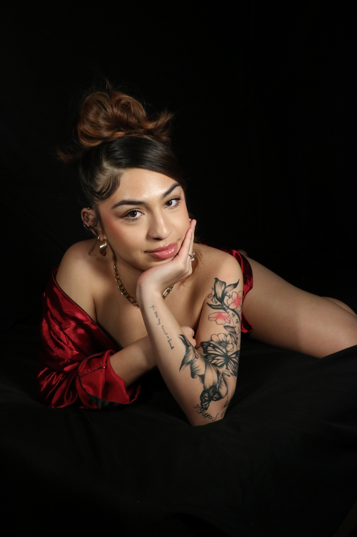 Studio portrait on black backdrop, chin resting on hand